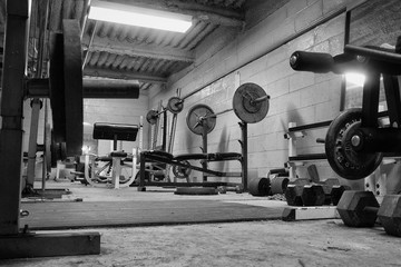 Black and white photo of a dirty, grungy ,hard core, weight room ,gym.Work out Room.
