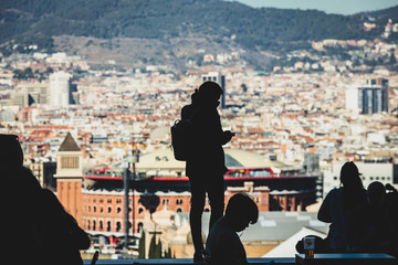 Unrecognizable silhouette of people in tourist place. Silhouette of man with city in background. Tourists admiring the landscape. 