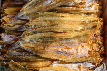 Top view stack of dried fish are sold in outdoor seafood market. Group dried fish dry on the sun light.