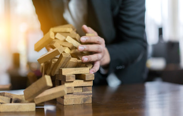 Hand of businessman pulling wood block fail on building tower at home and drape change, choice...