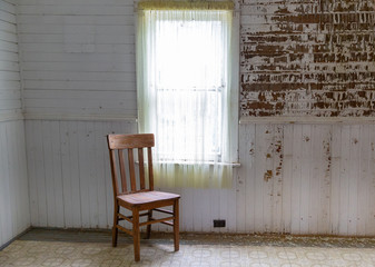 old wooden chair sitting in a corner in empty room