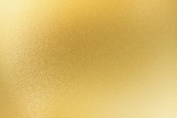 Shiny light gold metallic sheet, abstract texture background