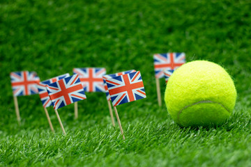 Tennis ball with Union Jack flag on green grass