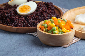 carrots corns and peas on wooden bowl