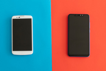 White and Black Smartphones on a Blue and Red Backgroun