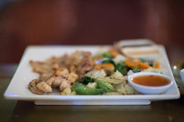 Grilled alligator meat, crocodile fillet with vegetables on a plate in a barbecue restaurant of Siem Reap, Cambodia
