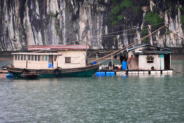 Fototapeta na wymiar Fisherman in Ha Long Bay, Fish boat and House fishermen in wonderful landscape of Halong Bay, Vietnam