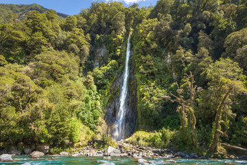 Waterfall in New Zealand Landscape. Beautiful powerful waterfall in forest environment in wilderness. New Zealand travel and exploring nature concept. Inspiring landscape background.