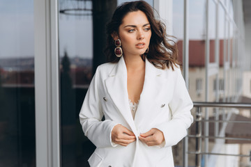 Pretty stylish business woman stands on the balcony near modern office.