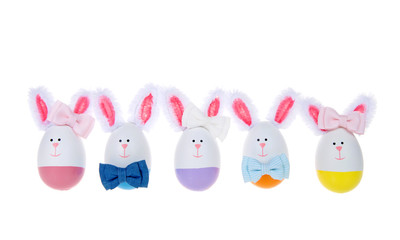 Row of Easter Eggs crafted into bunnies, boys and girls, wearing bow ties and bows on ear lined up isolated on white background.