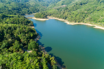 Obraz na płótnie Canvas Top down from Drone aerial view of rainforest with asphalt road around the dam