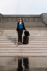 Business lady with suitcase on steps