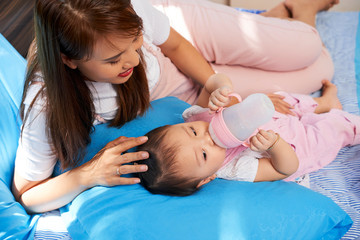 Obraz na płótnie Canvas Mother feeding child with baby formula