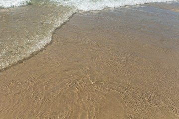 Fototapeta na wymiar Calm waves on the beach. Backgrounds and Textures