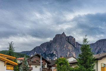 Fototapeta na wymiar Alpe di Siusi, Seiser Alm with Sassolungo Langkofel Dolomite, a house with a mountain in the background