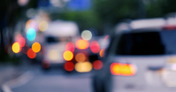 Defocused, blurred bokeh and abstract blurry of red taillights moving on night street. Royalty high-quality free stock video footage of colorful red light in night, glowing backdrop overlay for design