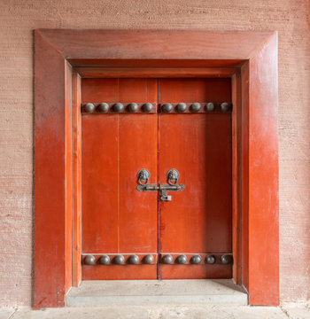 Red wooden door with lion's head door buckle