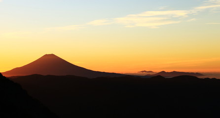 Fototapeta na wymiar 南アルプス光岳　山頂直下光岳小屋から　朝焼けに浮かぶ富士山とイ愛鷹山、箱根遠景