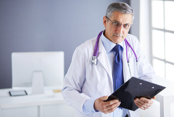 Male doctor writes notes on the clipboard in the hospital