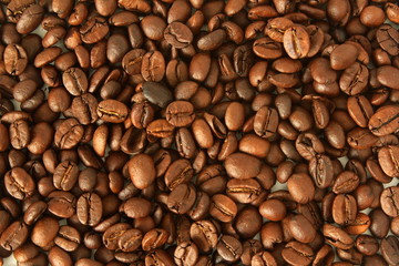 Naklejka premium dark roasted coffee beans closeup as background top view 