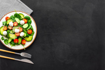 Healthy lunch. Fresh vegetable salad on black background top view space for text