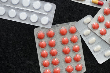 Pills and tablets packages  on a dark background close up