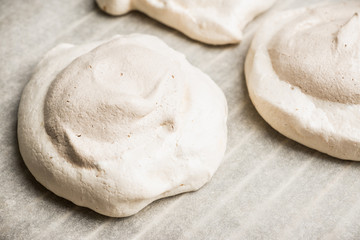 Chocolate meringue dessert decorated with glaze and chocolate powder. Selective focus.