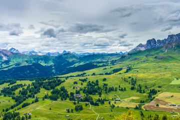 Fototapeta premium Alpe di Siusi, Seiser Alm with Sassolungo Langkofel Dolomite, lush green field in Seiser Alm Puflatsch Bullaccia