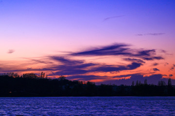 Dark clouds over orange sky background over the sea. Sunset in the countryside with a sky filled with clouds