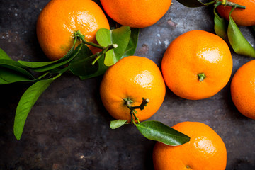 Fototapeta na wymiar Sweet juicy mandarines on the rustic background. Selective focus. Shallow depth of field. 
