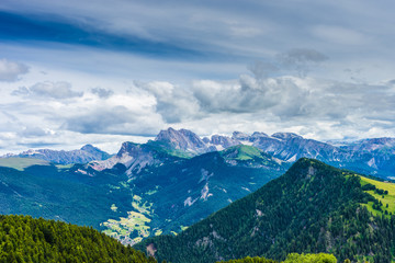 Fototapeta premium Alpe di Siusi, Seiser Alm with Sassolungo Langkofel Dolomite, a view of a large mountain in the background