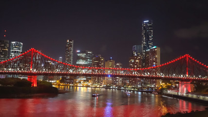 night shot of the story bridge in brisbane illuminated with red lights