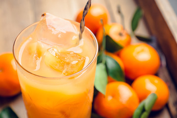 Fresh beverage with mandarines on the rustic background. Selective focus. Shallow depth of field.