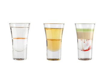 Set of alcohol shots on a white background. Three shots with popular types of strong alcohol.