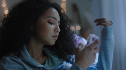 sad teenage girl crying at home feeling alone depressed teen thinking of emotional break up texting using smartphone sitting in bedroom