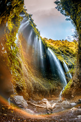 Majestic Madakaripura Waterfall flowing in rocky valley, Tallest waterfall in Deep Forest in East Java, Indonesia.