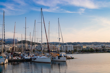 Beautiful cityscape port, arsenal, modern buildings, yachts, azure sea water on the background of stormy sky at evening, harbour of Rethymno, island of Crete, Greece, Southern Europe.