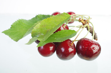 Sweet cherry fruits with leaves on a white background