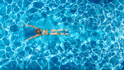 Active girl in swimming pool aerial drone view from above, young woman swims in blue water, tropical vacation, holiday on resort concept - Powered by Adobe