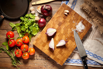 Top view on a beautiful cutting board with a knife and fresh vegetables