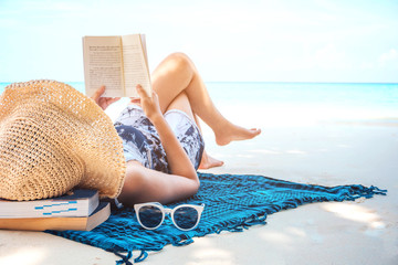 Summer Beach Holiday Woman reading a book on the beach in free time .