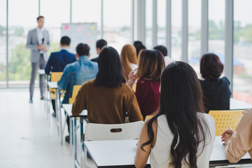 Asian male speaker is speaking at seminars and workshops to the people in the meeting.
