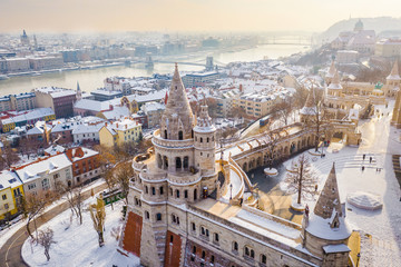 Budapest, Hungary - Aerial view of the snowy Fisherman's Bastion with Szechenyi Chain Bridge and St. Stephen's Basilica at background on a snowy winter morning - obrazy, fototapety, plakaty
