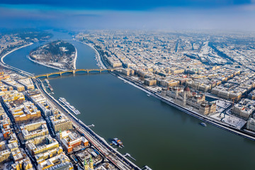 Fototapeta na wymiar Budapest, Hungary - Winter morning over Budapest with snow, Parliament building, Margaret Bridge and Margaret Island