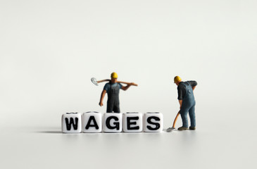 Fototapeta premium 'WAGES' word in white cube. Miniature people.