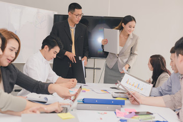 A group of Asian businessmen are discussing their work.The president and secretary presentations to the employees.