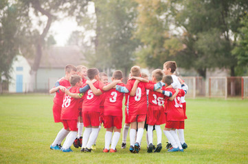 Obraz premium Young soccer players in hug celebrating victory
