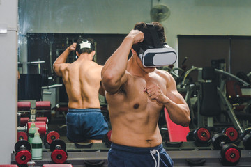 Asian men have muscle Playing vr machine standing in front of glass in gym