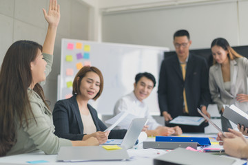 A group of Asian businessmen are discussing their work.The woman asked while the president and secretary was presenting.