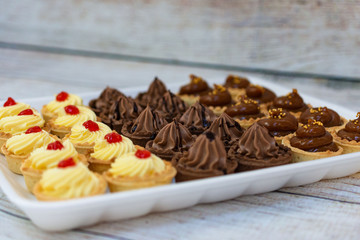 Tasty tarlets with vanilla cream and raspberry confi, chocolate cream and toffie